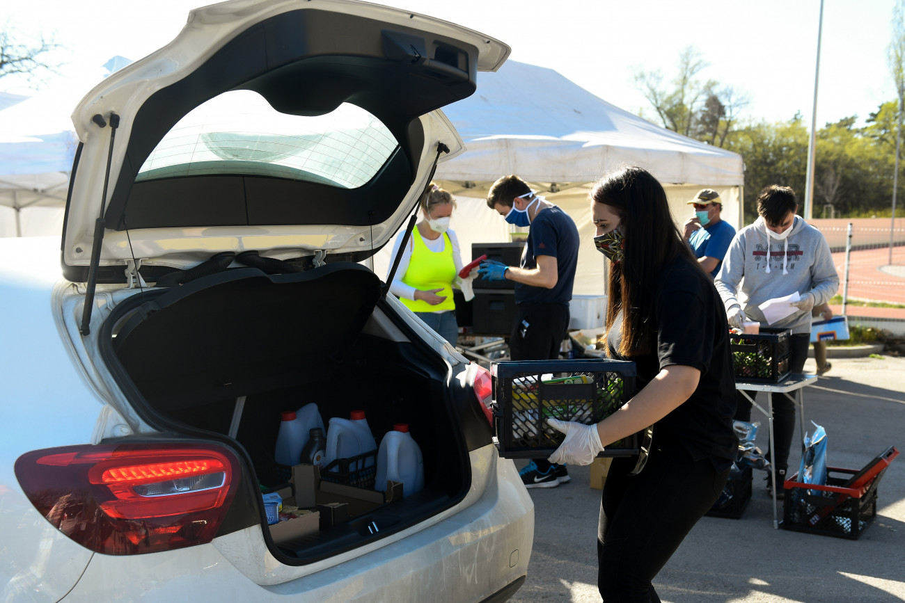 Egy vásárló autójának csomagtartójába pakolja egy segítő az árut. MTI/Koszticsák Szilárd