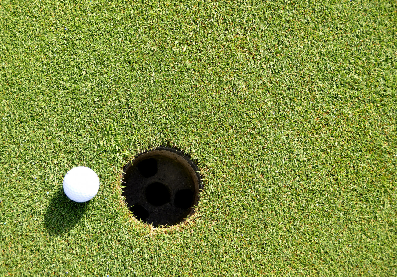 Golf ball near at hole.