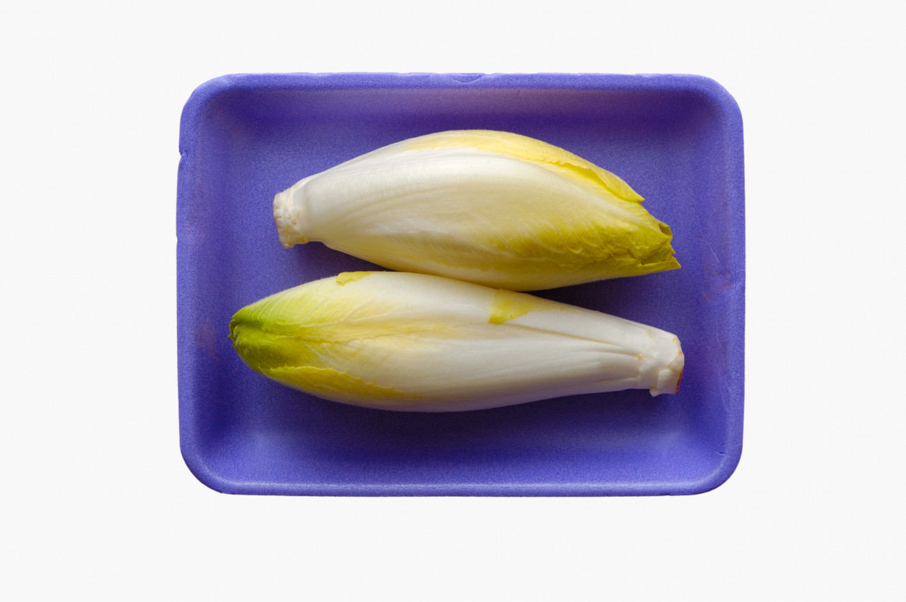 Close-up of two whole endives packed on purple polystyrene board